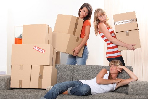 Professional movers carrying household items through a residential property